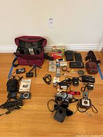 Overview of all cameras, accessories, bag and cases laid out on floor