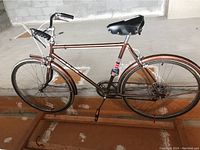 Side view of the entire CCM Elite bike showing brown frame, black saddle, fenders and wheels