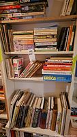 Photo showing several shelves of books including health, natural medicine, drug references, and healing books.