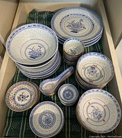 Drawer view of assorted dishes including bowls, plates, cups and spoons