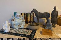 Overview of lot showing all figurines and decorative items placed on table with lace cover and runner