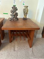 Front view of rectangular teak side table with decorative items on top