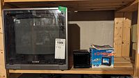 Front view of Sony CRT television and Casio portable TV on wooden shelf