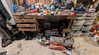 Wide view of workbench showing drawers, tools under bench, and footwear on floor
