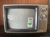 Front view of 13-inch Candle CRT television with woodgrain plastic housing, silver bezel, analog rotary tuner dials