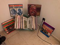 Two displayed albums (Ella Fitzgerald & Louis Armstrong, The Greatest of Louis Armstrong) above rack of LPs