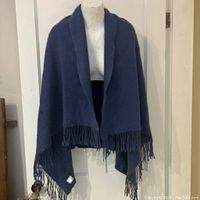 Steel grey blue cashmere shoulder wrap displayed on a mannequin showing a relaxed drape and fringe edges.