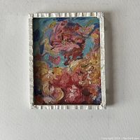 Full view of a framed abstract oil painting showing colorful textured brushstrokes in warm and cool tones.