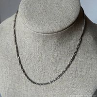 Full view of the sterling silver necklace displayed on a mannequin showing the chain length and texture.