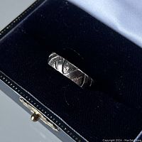 Photo of sterling silver ring in blue velvet box interior showing engraved geometric pattern and 925 mark indication