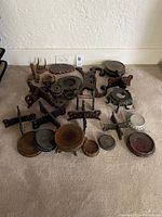 Various carved wood and black finish Asian-style bases and pedestals arranged on carpet floor, sizes from 1 to 5 inches tall.