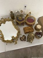 Full display of lot: mirror tray, four perfume bottles, jewelry and powder boxes, porcelain dish