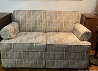 Front view of the love seat showing fabric pattern, cushions, and armrests.