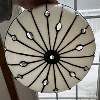 Top view of the white glass dome shade with black decorative lines and clear oval glass accents arranged in a radial sunburst pattern.