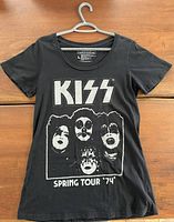 Full view of black ladies large KISS T-shirt showing front design with band logo and faces of band members in white, labeled Spring Tour '74.