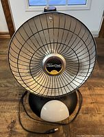 Front view of the Presto HeatDish parabolic electric heater showing large round heating dish with protective grill and base with footlight and power cord.