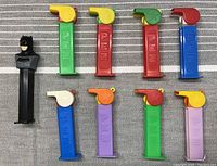All 9 PEZ dispensers with various colored stems and tops, including a Batman character dispenser