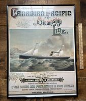 Full view of reproduction poster framed in black plastic, showing detailed steamship on water with text and vintage style.