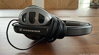 Side view of gray Sennheiser HD 480 II headphones with black padded headband and wired cable coiled around ear cup.