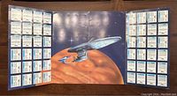 Tri-fold album showing backs of all 48 cards with detailed text and statistics for each, displayed around a large USS Defiant image in the center.