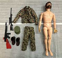 All components laid out flat: nude figure, jacket, pants, cap, boots, two rifles.