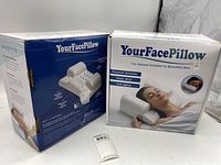 Two boxed Your Face Pillow products, showing front and side packaging with branding and product benefits.