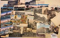 An overall view of about 60 older German postcards laid out, showing a variety of cityscapes, architectural images, landscapes, and floral designs in color and black & white.