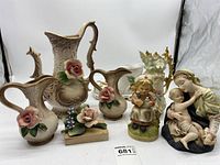 View of all porcelain figurines and pitchers together.