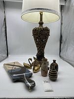 Full group photo showing the lamp, brass swans, pottery vessels, and ceramic serving tray on a white background.