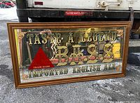 Full front view of the large mirror showing text 'Taste A Legend Bass Imported English Ale' with red triangle logo and wood frame.