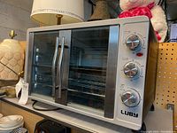 Front angled view of Luby convection oven showing double glass doors with metal handles and three control knobs on the right side panel.