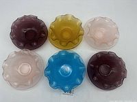Top view of all 7 candy dishes showing different colors and ruffled edges