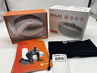 View of the heated eye massager inside the box along with the black storage pouch, user manual and lot sticker.