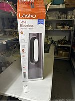 Full view of packaged Lasko Safe Bladeless Ceramic Heater showing front and top control panel graphic.