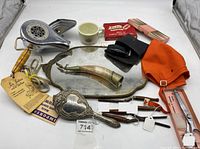 Full view of lots vanity items including hair curler, hand mirror, powder flask, cup, lipstick, shears box, orange wrap, and clipper case.