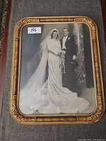 Front view of the vintage ornate framed wedding portrait showing the bride and groom in classic attire.