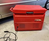 Front view of red Marlboro Coleman electric cooler with power cord and car plug visible