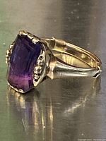 Oblique side view showing large faceted amethyst and band profile