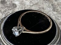 Ring angled on black velvet cushion showing profile and band