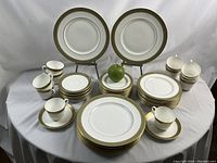 Overall layout of all plates, saucers and cups with green apple for size reference