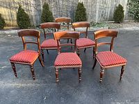 Six mahogany chairs grouped outdoors showing overall condition and style