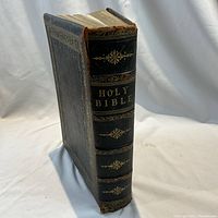 Spine view of leather-bound Bible showing gilt 'Holy Bible' title and raised bands