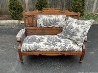 Angled view from left front showing carved crest rail, left arm and overall form