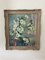 Frontal view of oil painting of white flower still life in carved wooden frame