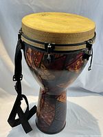 Full view of painted synthetic-shell djembe with shoulder strap attached
