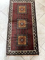 Full top-down view of rug on tile floor showing entire pattern and dimensions.