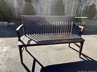 Front three-quarter view of bench showing seat, backrest slats and armrests