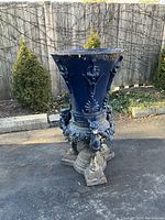 Front view of entire urn showing overall shape, lion head motifs, tripod base