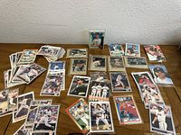 Multiple baseball cards laid out in protective sleeves showing players in various baseball uniforms from different teams in action or portrait poses.