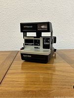 Front view of the Polaroid Spirit 600 instant camera showing flash, lens, viewfinder, and branding.
